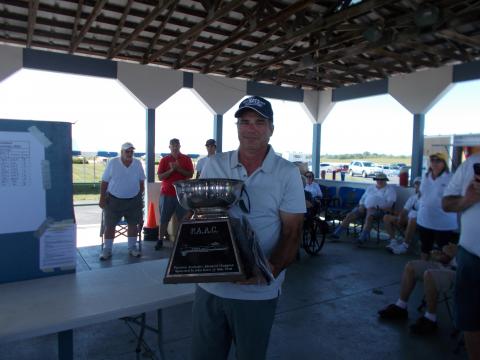 Tom Luciano holding the perpetual trophy for the Advanced winner.